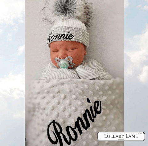 baby in blanket and hat