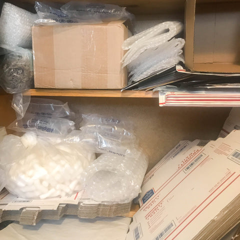 Shipping boxes and supplies in cabinet