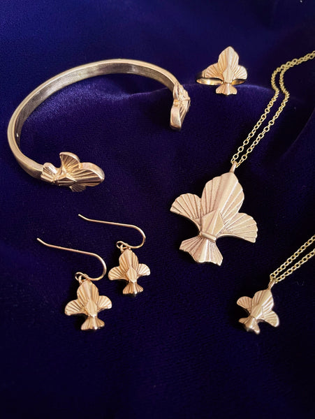 MIMOSA Handcrafted's Fleur De Lis Jewelry Collection is Displayed on Purple Velvet