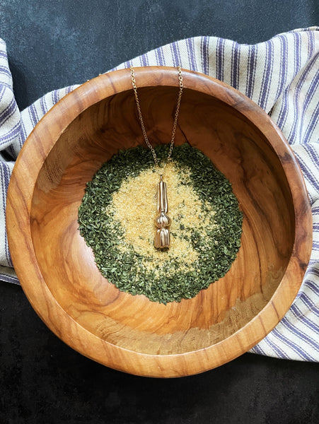 MIMOSA Handcrafted's Cajun Holy Trinity Necklace Rests in a Bowl of Seasonings