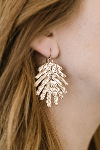 A Woman Wears MIMOSA's Large Bronze Mimosa Leaf Earrings