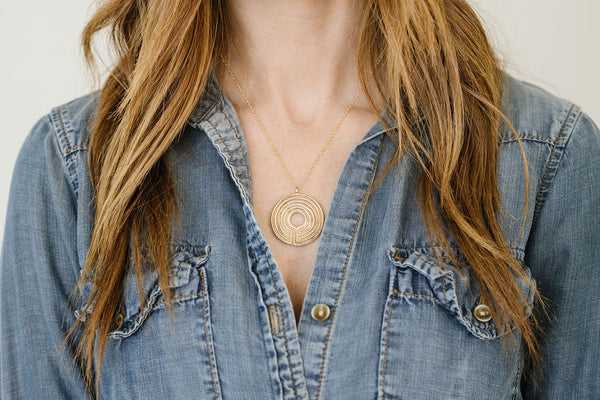 A Woman Wears MIMOSA's Large Bronze Labyrinth Necklace
