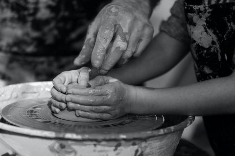 image of two hands working with clay 