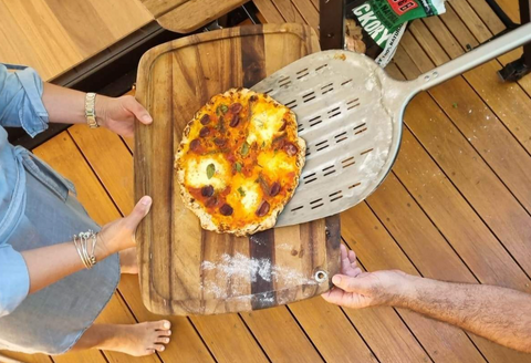 cooking together, image of two hands sharing pizza