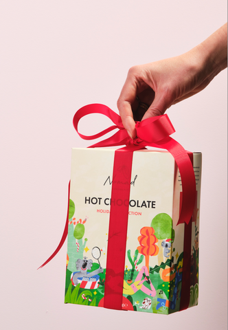 image of Nomad chocolate gift box designed by Elin matilda and wrapped in a red ribbon