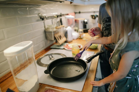 Woman puts oil in frying pan