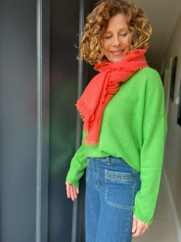 Women wearing a green cashmere jumper and coral scarf