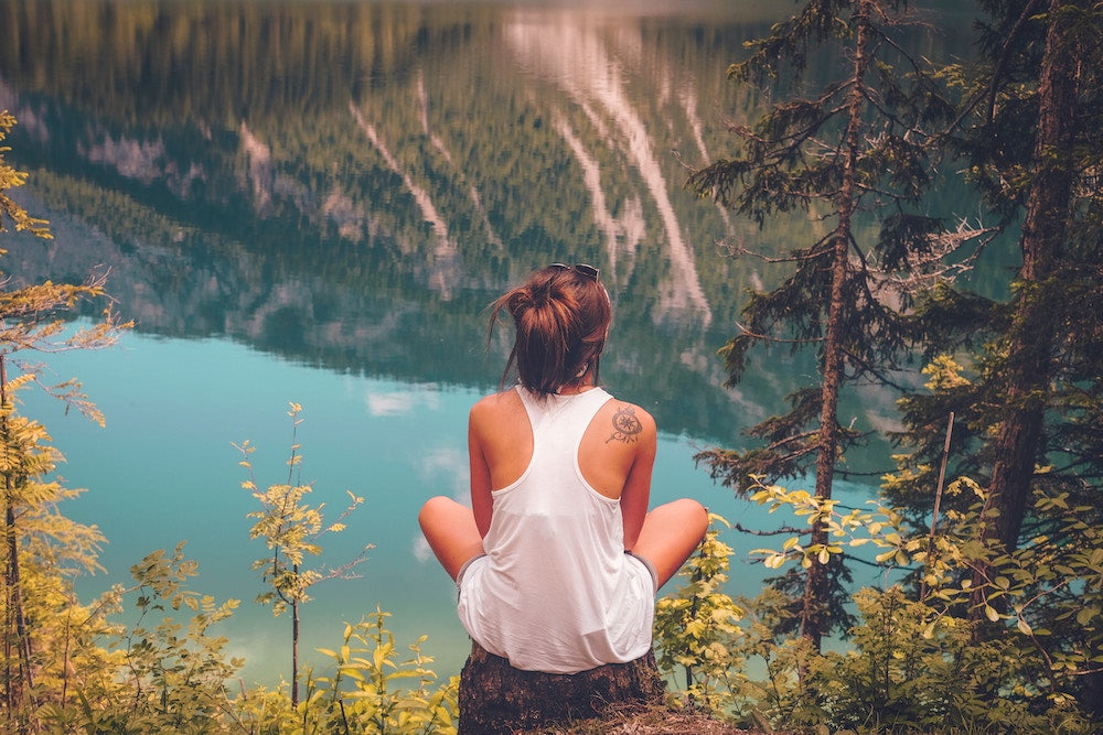 woman on rock looking over a river