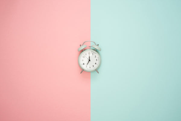 alarm clock on a pink and blue background