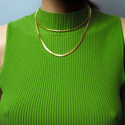 model wearing medusa link chains gold green top
