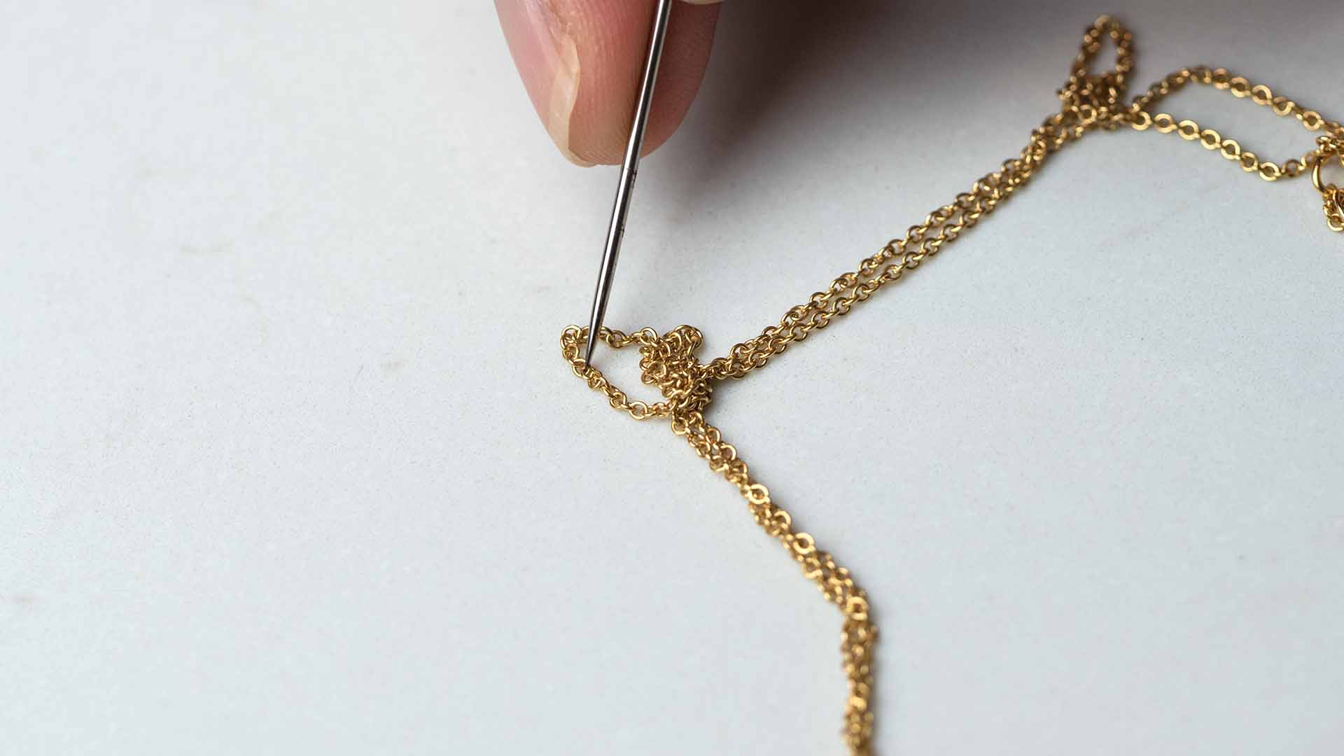 pin untangling gold necklace