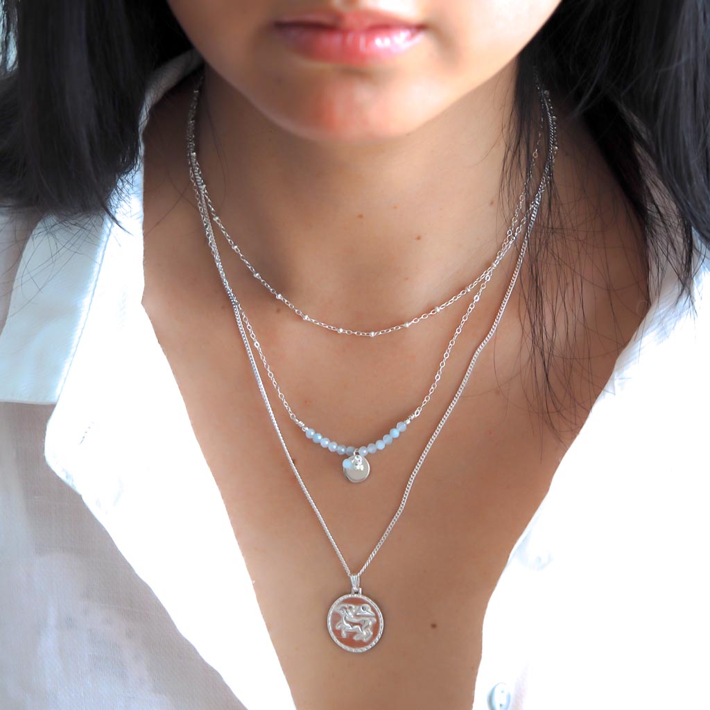 Model wearing Aries  aura Satellite chain necklaces silver layered
