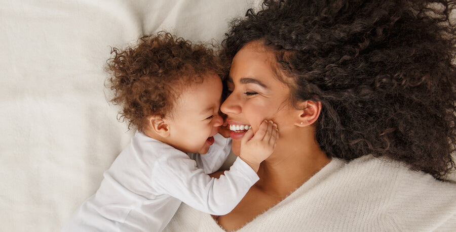 mother and child lying down smiling