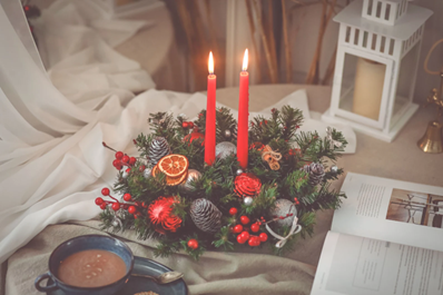 A Christmas wreath centrepiece with bright red tapered candles and dehydrated orange slices. Source: Pexels