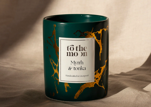 A green and gold retro-inspired candle from <span data-mce-fragment="1"><a href="https://shoptothemoon.com/collections/soy-candles/products/bespoke-candles?variant=43187452117180" data-mce-fragment="1" data-mce-href="https://shoptothemoon.com/collections/soy-candles/products/bespoke-candles?variant=43187452117180">To The Moon</a></span>.