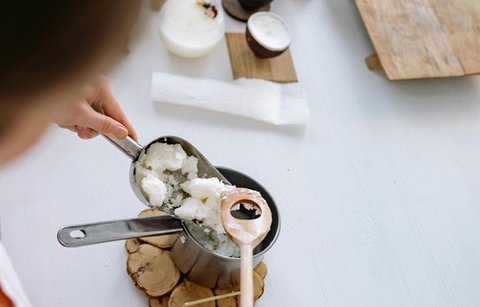 A candle maker melting wax into a pan. Sourced from Pexels.