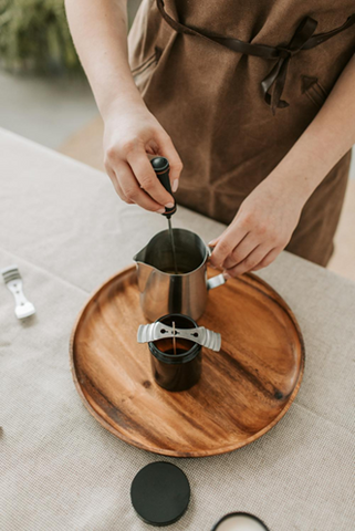 A person stirring melted candle wax, about to pour it into a vessel with a wick holder. Sourced from <span data-mce-fragment="1"><a href="https://www.pexels.com/photo/person-making-a-candle-6755799/" data-mce-fragment="1" data-mce-href="https://www.pexels.com/photo/person-making-a-candle-6755799/">Pexels</a></span>.