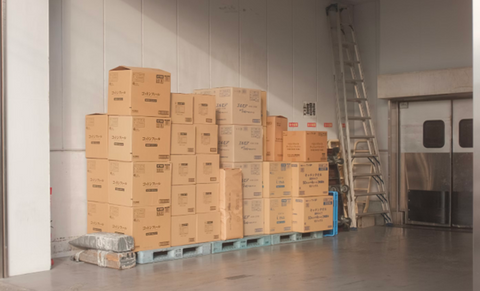 A stack of full cardboard boxes on a set of pallets. Sourced from <span data-mce-fragment="1"><a href="https://unsplash.com/photos/brown-cardboard-boxes-on-white-floor-tiles-8wy9mGgmGoU" data-mce-fragment="1" data-mce-href="https://unsplash.com/photos/brown-cardboard-boxes-on-white-floor-tiles-8wy9mGgmGoU">Unsplash</a></span>.