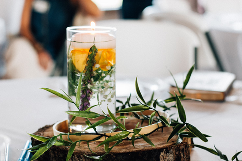 A cylindrical vessel filled with water and flowers and topped with a floating candle. Source: <span data-mce-fragment="1"><a href="https://unsplash.com/photos/clear-glass-cup-filled-with-yellow-green-and-white-leaves-and-water-on-brown-wooden-platform-rtQgpPEFVHQ" data-mce-fragment="1" data-mce-href="https://unsplash.com/photos/clear-glass-cup-filled-with-yellow-green-and-white-leaves-and-water-on-brown-wooden-platform-rtQgpPEFVHQ">unsplash</a></span>.