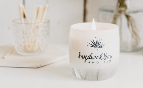 A product image of <span data-mce-fragment="1"><a href="https://sandwickbaycandles.com/product/white-jar-candle/" data-mce-fragment="1" data-mce-href="https://sandwickbaycandles.com/product/white-jar-candle/">Sandwick Bay</a></span> candle in a minimalist white jar.