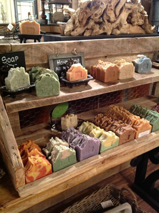 A tiered wooden shelf display containing colourful handmade soap. Sourced from <span data-mce-fragment="1"><a href="https://www.pinterest.co.uk/pin/633881716329272749/" data-mce-fragment="1" data-mce-href="https://www.pinterest.co.uk/pin/633881716329272749/">Pinterest</a></span>.