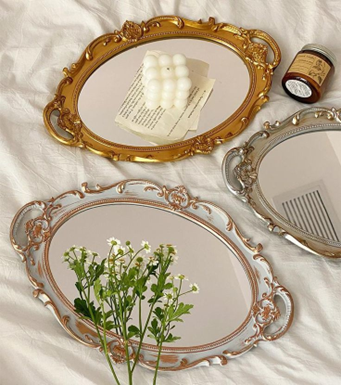 A trio of vintage oval mirrored trays with candles and flowers laid over them. Sourced from <span data-mce-fragment="1"><a href="https://www.pinterest.co.uk/pin/929008229359932981/" data-mce-fragment="1" data-mce-href="https://www.pinterest.co.uk/pin/929008229359932981/">Pinterest</a></span>.
