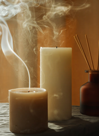 A photo of pillar candles billowing smoke after being blown out. Image source: Unsplash