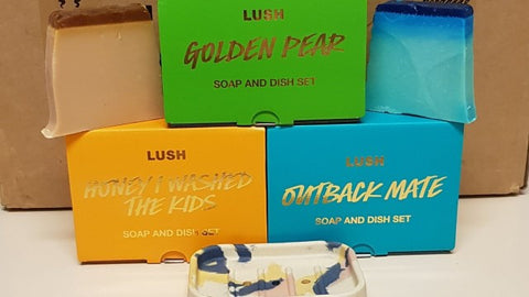 LUSH soap packaging in vivid colours and golden text. Sourced from YouTube.