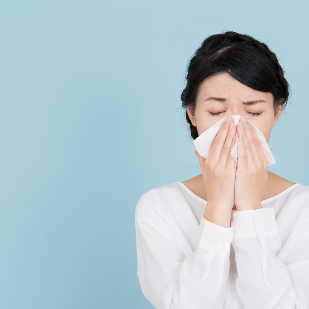 women sneezing into a tissue