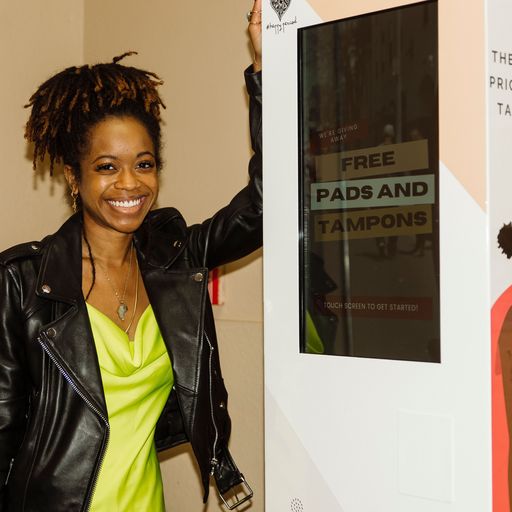 Chelsea VonChaz stands next to a touch screen kiosk that helps people receive free pads and tampons.