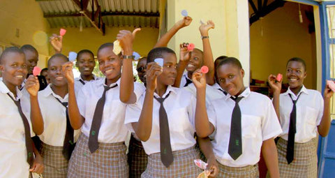 Girls in school holding menstrucl cups