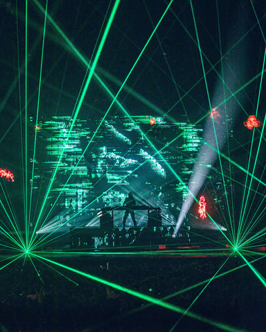 DJ Alan Walker performs for audience with laser show.