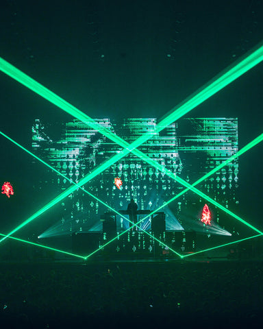 DJ Alan Walker performs for audience with laser show.