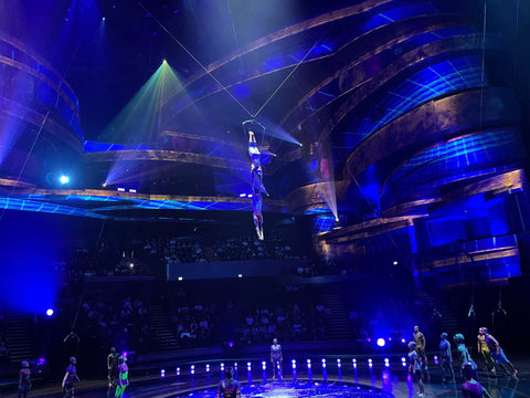 Acrobats dangle in the air as suspense fills the room