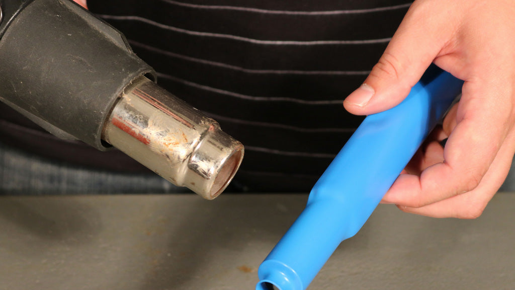 DIYer Applying Shrink Tubing With A Hand Held Heat Gun