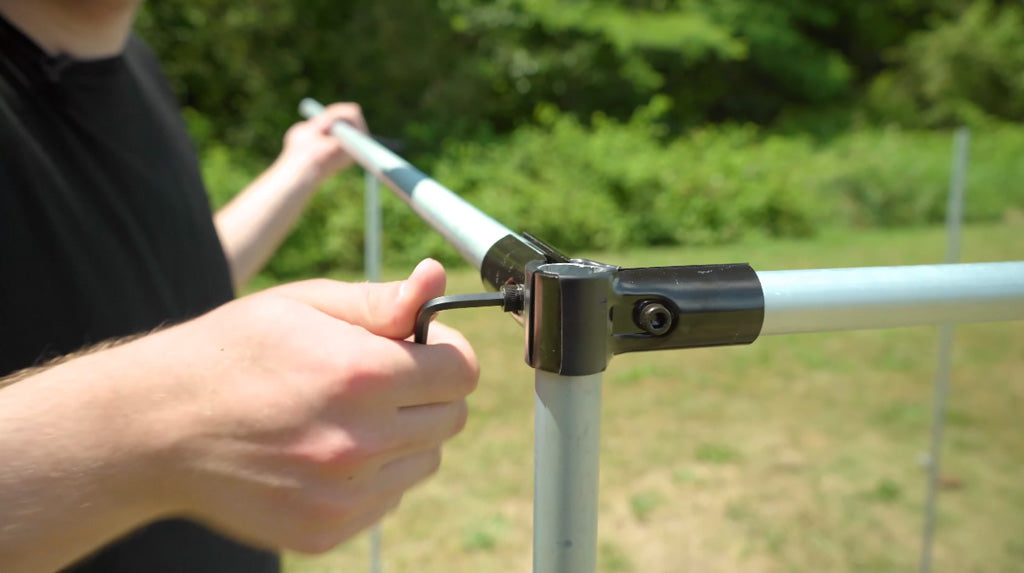 Man assembling a connector and conduit with a hex wrench