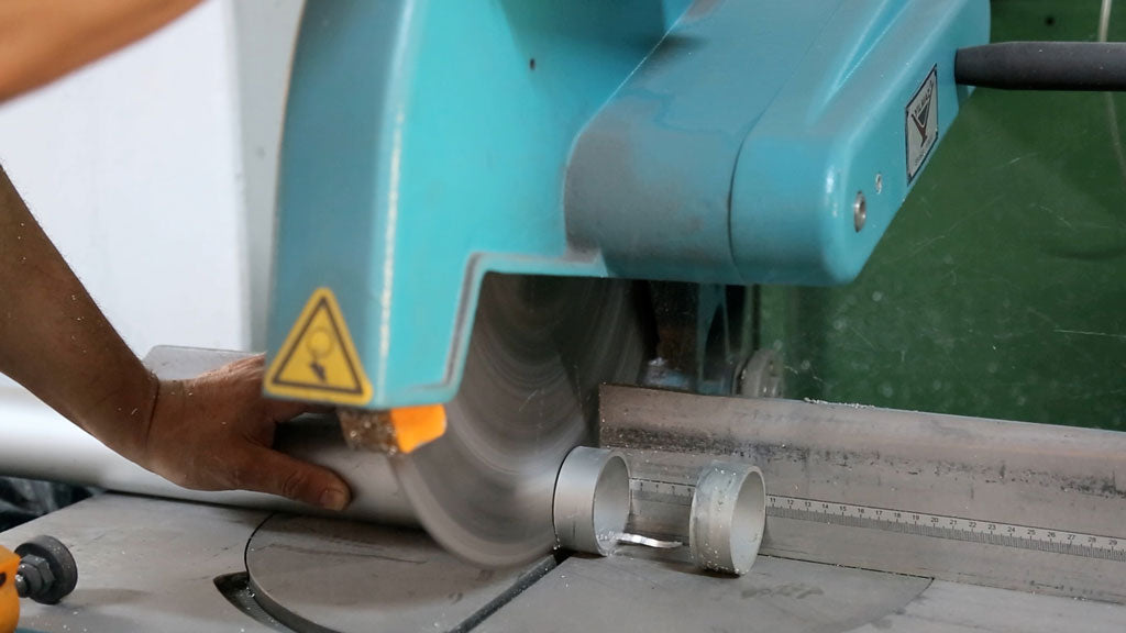 Chop saw cutting through metal pipe on workbench