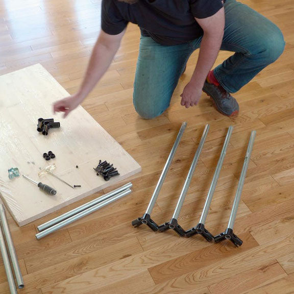 Man Adding Pipe Connectors To Desk