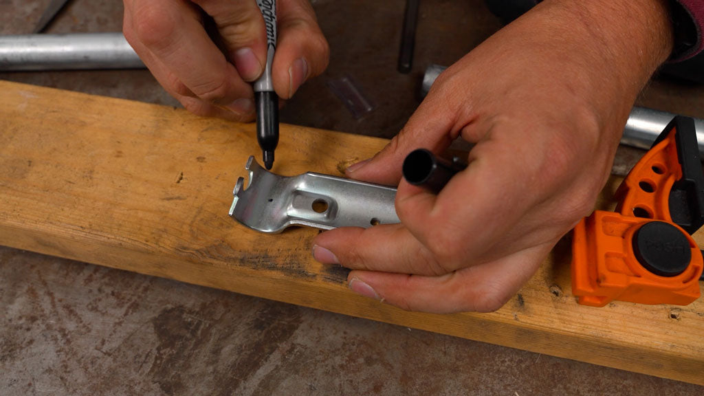 DIY builder marking a connector clamp with a sharpie