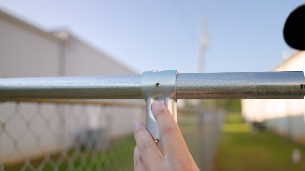 Builder assembling a pipe connector over top of two pieces of Top Rail