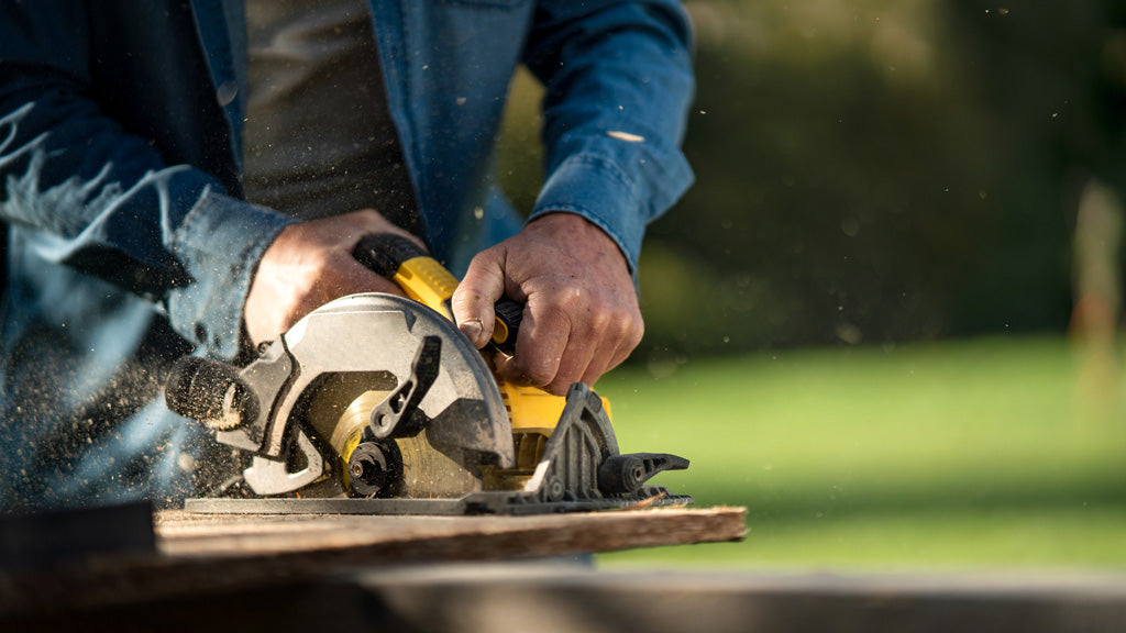 Gardener cutting pieces of wood with powered circular saw