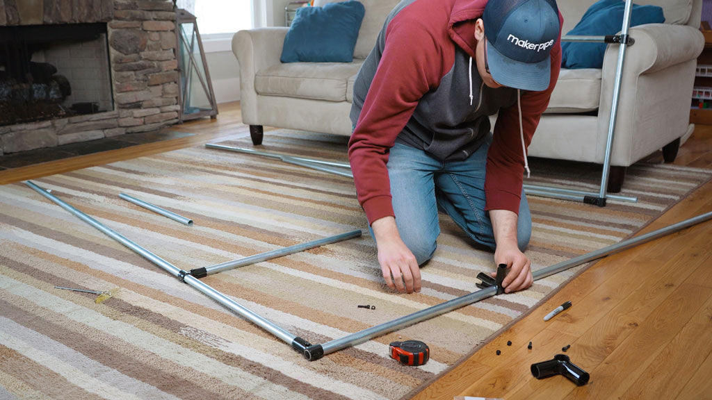 man assembling pipe build with clamp style connectors