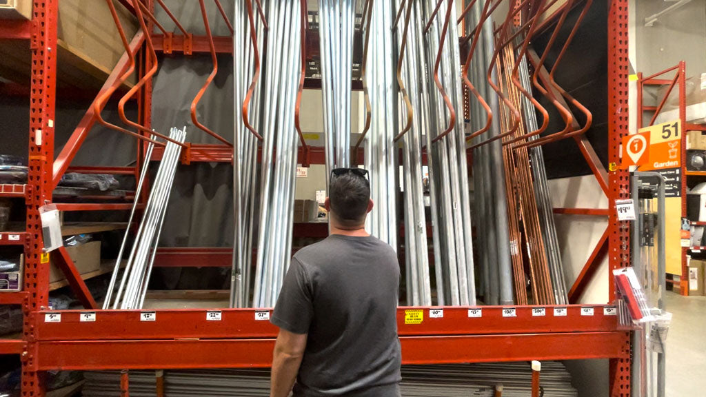 man inspecting electrical pipe at home improvement store