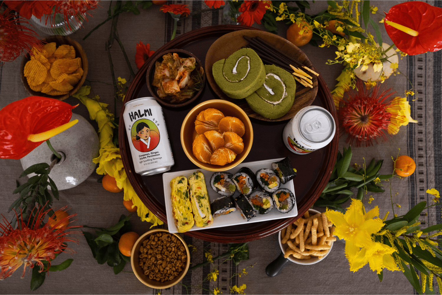 Lifestyle photo of Halmi sparkling beverage on a tablescape with florals and Korean bites.