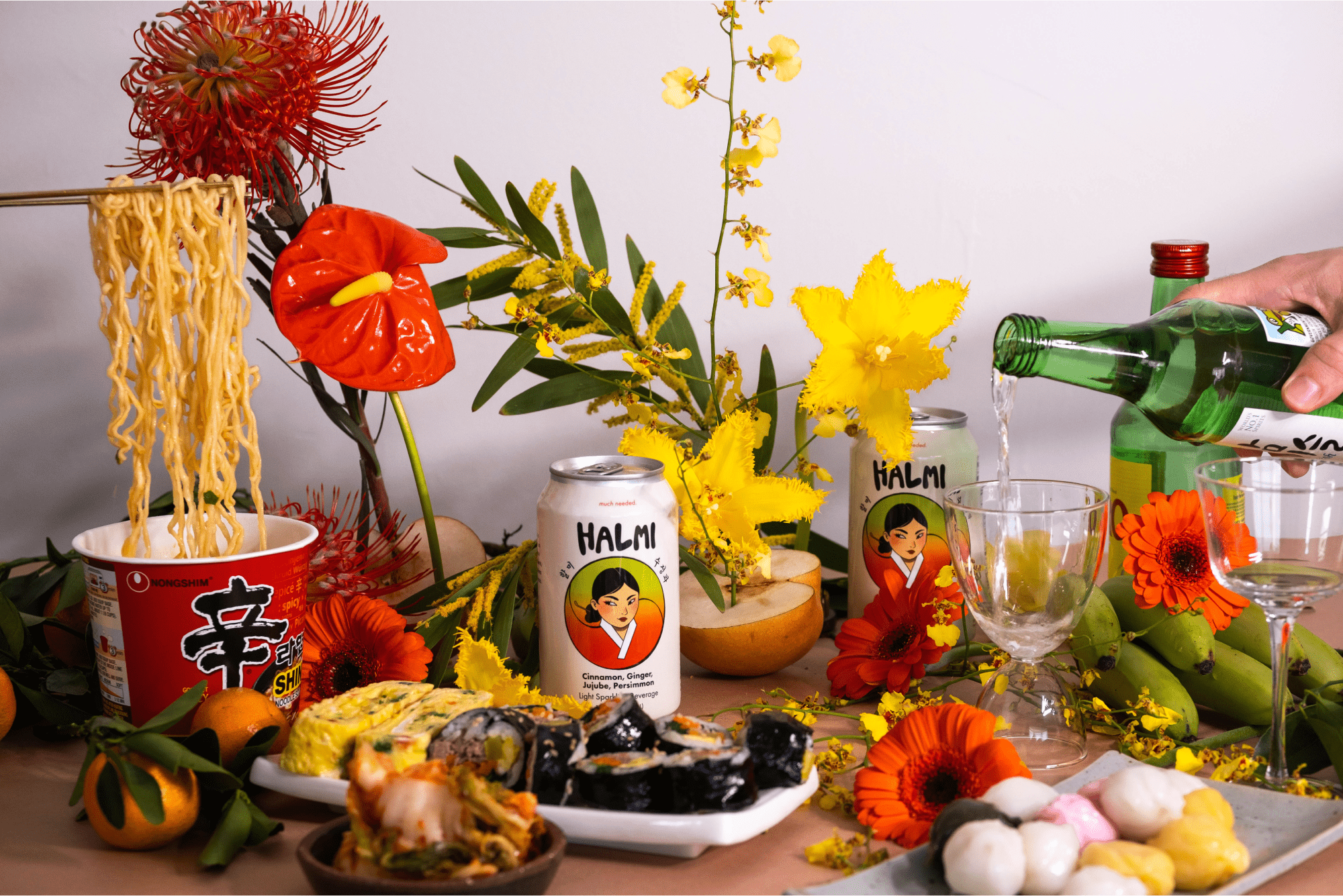 Lifestyle photo of Halmi sparkling beverage on a tablescape with florals and Korean bites.