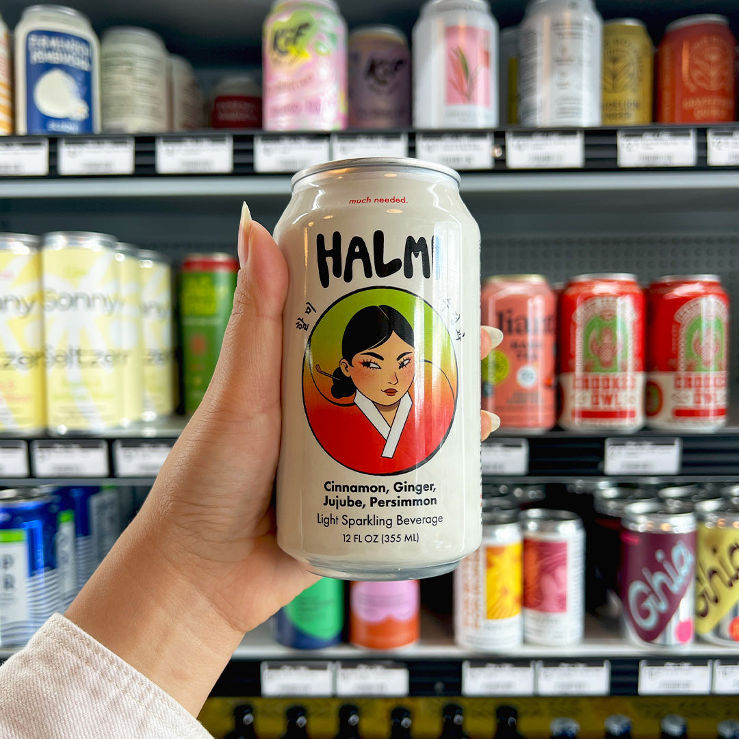 A can of Halmi sparkling beverage in front of a market's drink refrigerator..