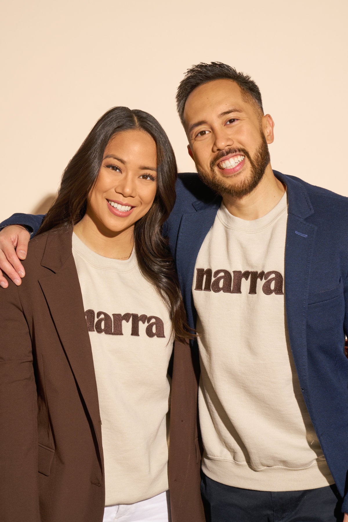 A headshot photo of Victoria and Miggy Reyes, the sibling co-founders of Narra, wearing Narra branded sweaters.