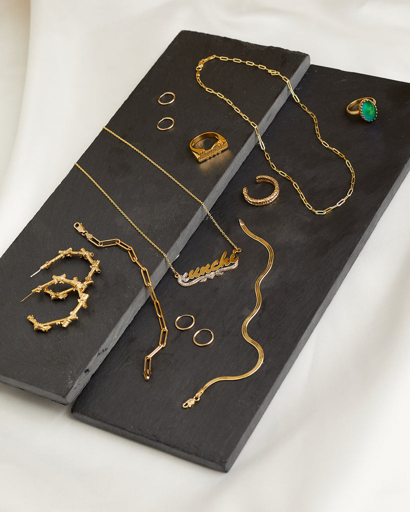 Nunchi jewelry, including necklaces, earrings, bracelets, and rings, laid out on two gray rectangular plates.