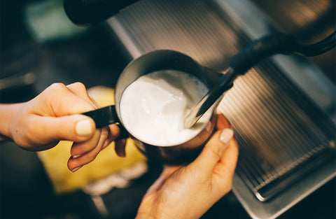 Espresso makinesinin süt çubu%u011Fuyla pitcher içerisindeki sütün köpürtülme an%u0131 gösterilmektedir.