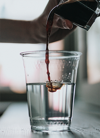 beyaz masa üzerinde s%u0131cak suya espresso koyarak amerikano yap%u0131m%u0131